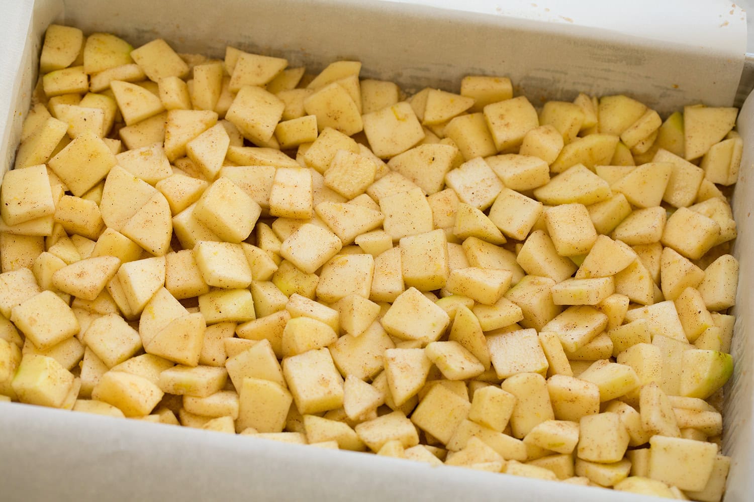 Apple Pie Bars Chopped apple mixture spread over crust layer in baking dish.