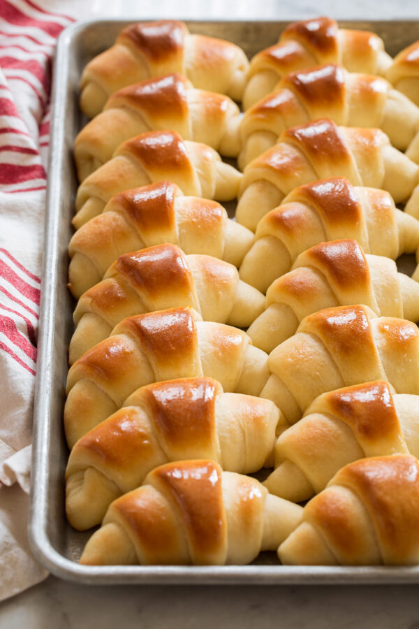 Sheet pan filled with rows of baked dinner rolls.