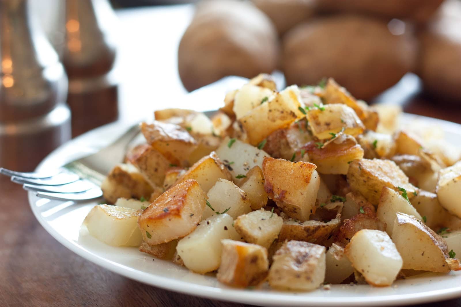 breakfast potatoes perfectly browned and crisp and shown on a serving plate.