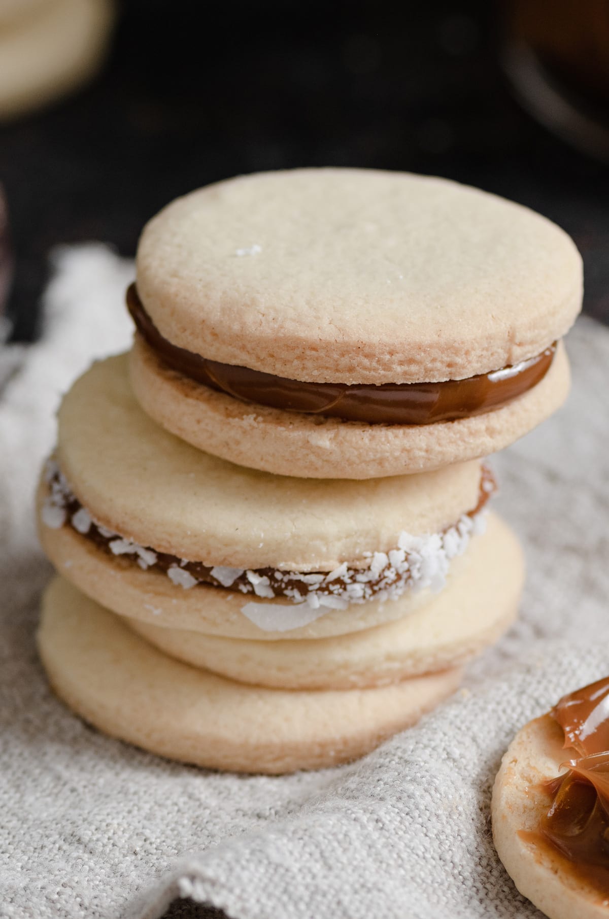 Alfajores Cookies {Dulce de Leche Sandwich Cookies} Close up image of stack of dulce de leche filled alfajores sandwich cookies
