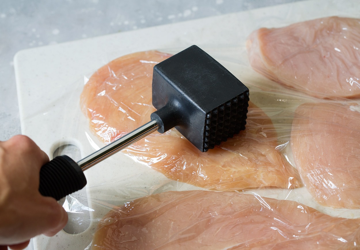 BEST Chicken Parmesan recipe! Pounding chicken flat with meat mallet for chicken parmesan.