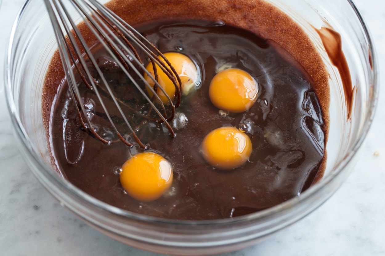 The BEST Flourless Chocolate Cake! Whisking eggs into flourless chocolate cake mixture in mixing bowl.