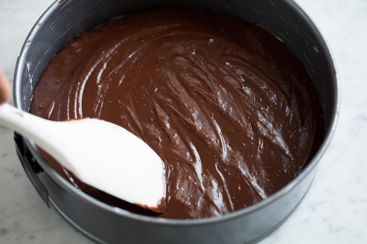 The BEST Flourless Chocolate Cake! Spreading flourless chocolate cake batter into a 9-inch springform pan.