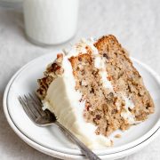 Single slice of homemade hummingbird cake on a white dessert plate.