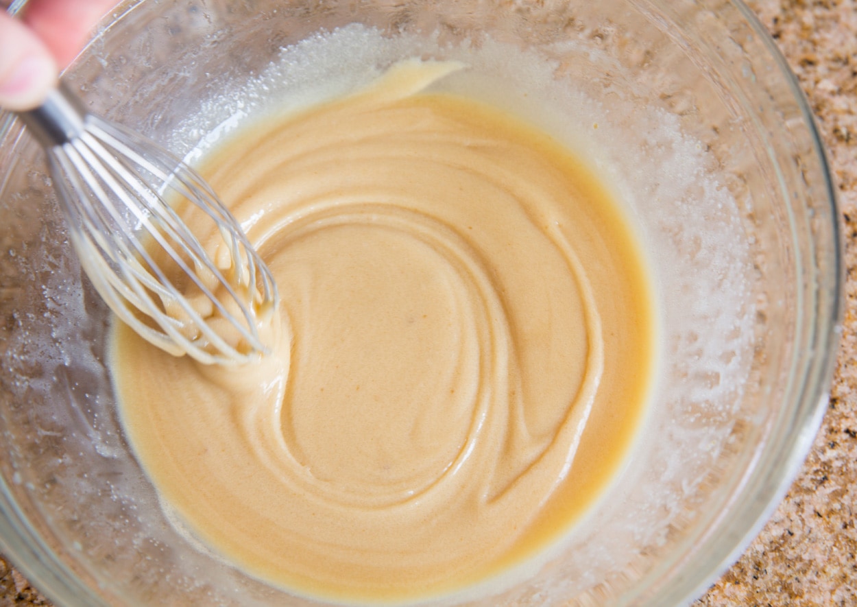 Microwave Caramels Showing how to make caramel. Whisking butter, corn syrup, sweetened condensed milk, salt and sugar in glass mixing bowl.