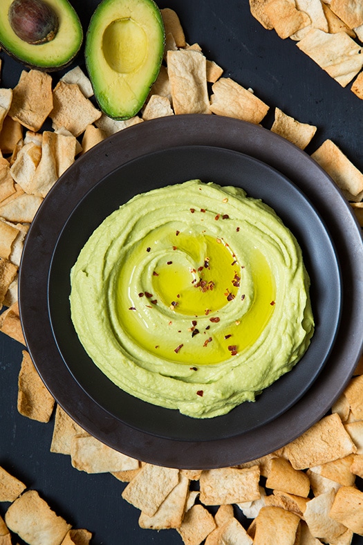 An overhead shot of Avocado Hummus in a bowl with crackers