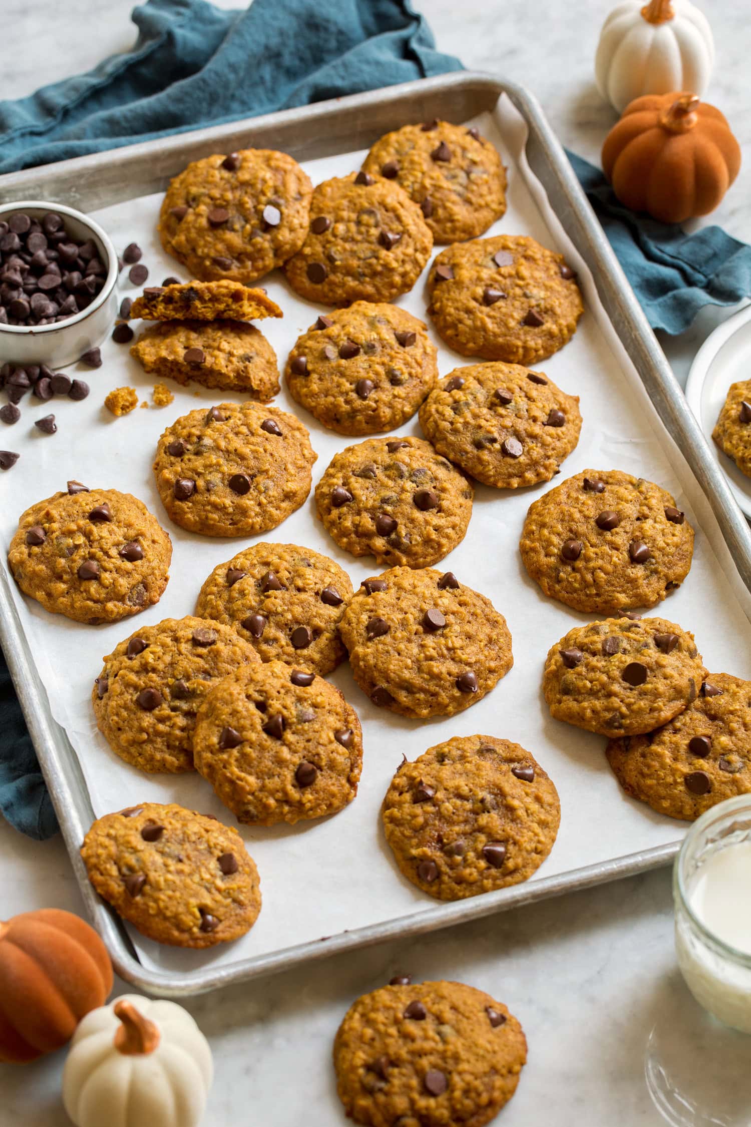 Pumpkin Oatmeal Chocolate Chip Cookies Pumpkin oatmeal chocolate chip cookies spread on parchment lined baking sheet.