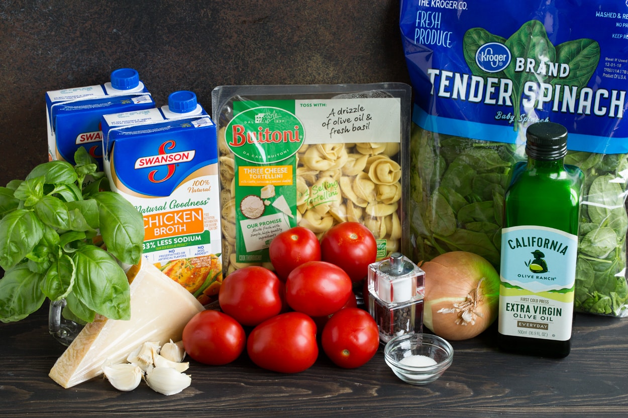 Tortellini Soup with Fresh Spinach Tomato and Garlic Ingredients needed to make tortellini soup shown here including tortellini, spinach, tomatoes, onion, parmesan, garlic, chicken broth, basil, olive oil.