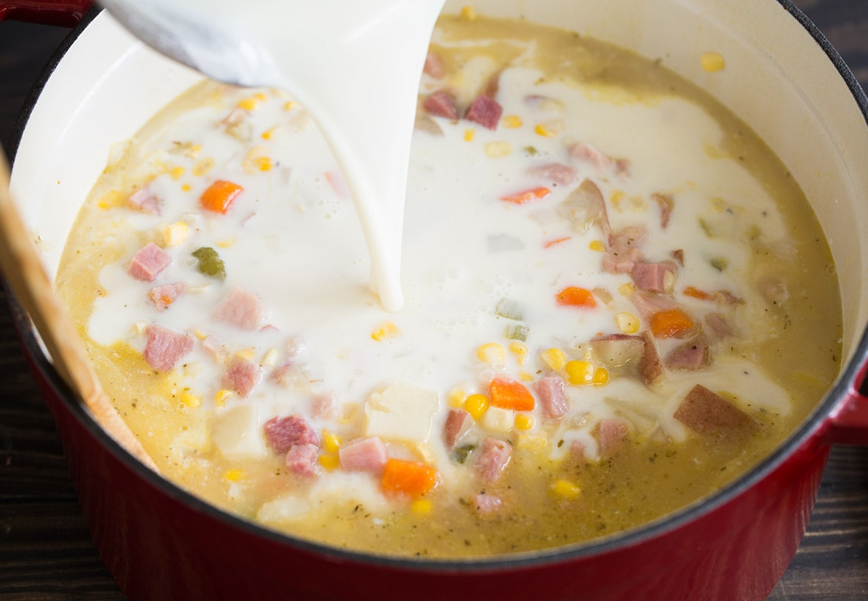 Creamy Ham Potato Corn Chowder adding milk mixture to soup in pot