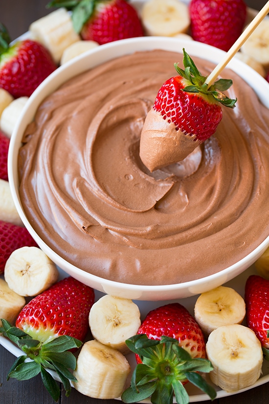 Chocolate Fruit Dip | Cooking Classy strawberry being dipped into bowl of Chocolate Fruit Dip