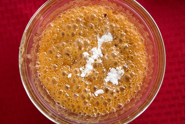 Peanut Brittle Adding baking soda to mixture in mixing bowl.