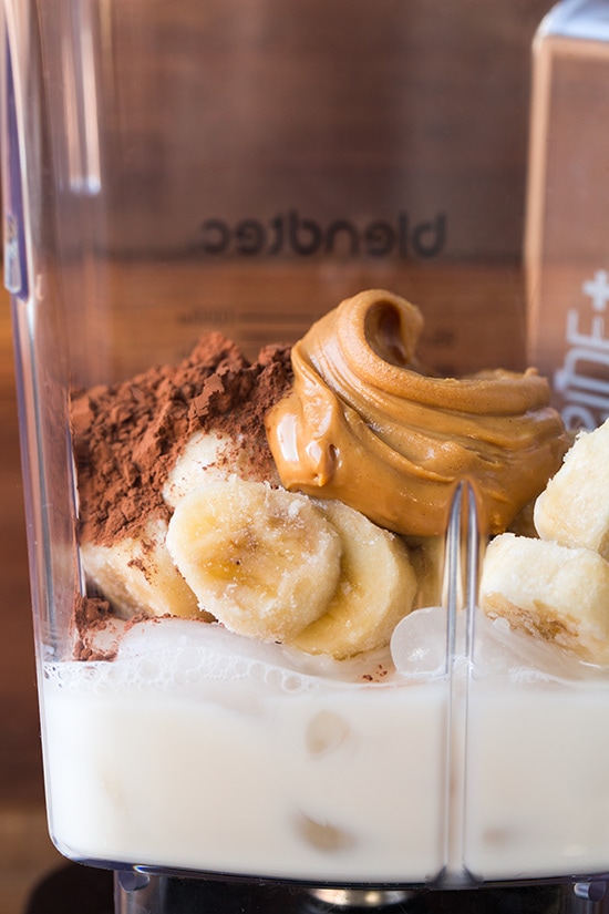 Chocolate Peanut Butter Banana Shake. This banana shake is not only delicious but healthy and so easy to whip up on busy mornings. It's made with simple ingredients and tastes incredible! | Healthy Breakfast Shake | Healthy Banana Shake | #cookingclassy #shakes #banana #chocolate Ingredients for a chocolate banana shake in a blender