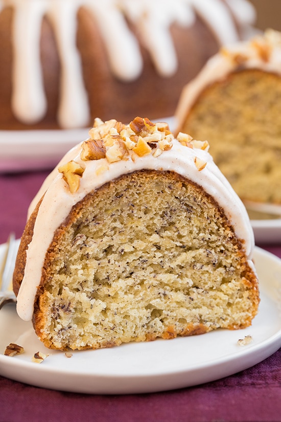 slice of Banana Bundt Cake with Cinnamon Cream Cheese Icing on white plate