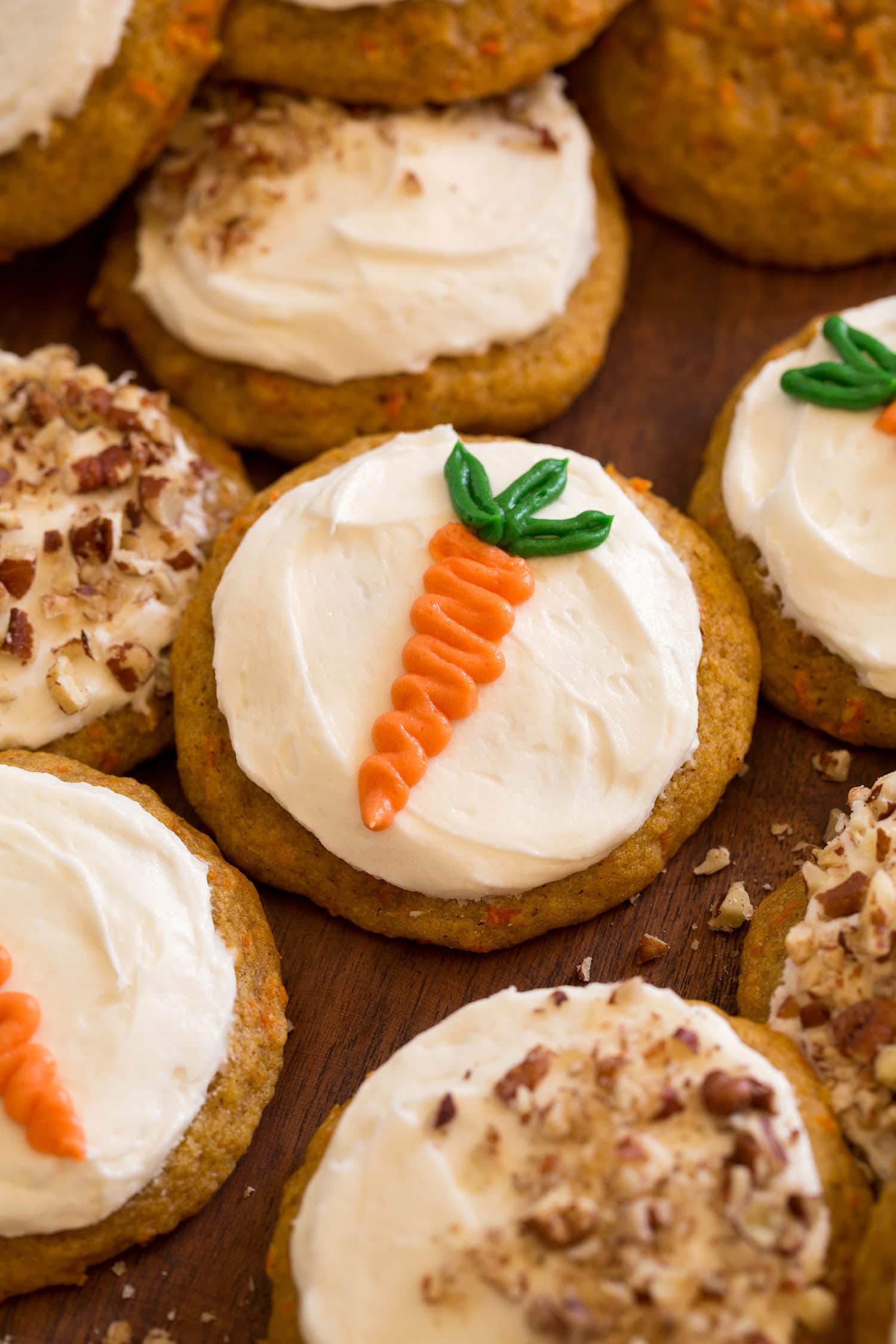 Close up photo of carrot cake cookie with frosting and carrot piped decoration.
