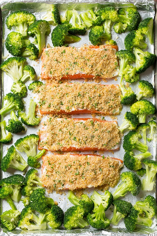 Parmesan crusted salmon on lined baking sheet with broccoli