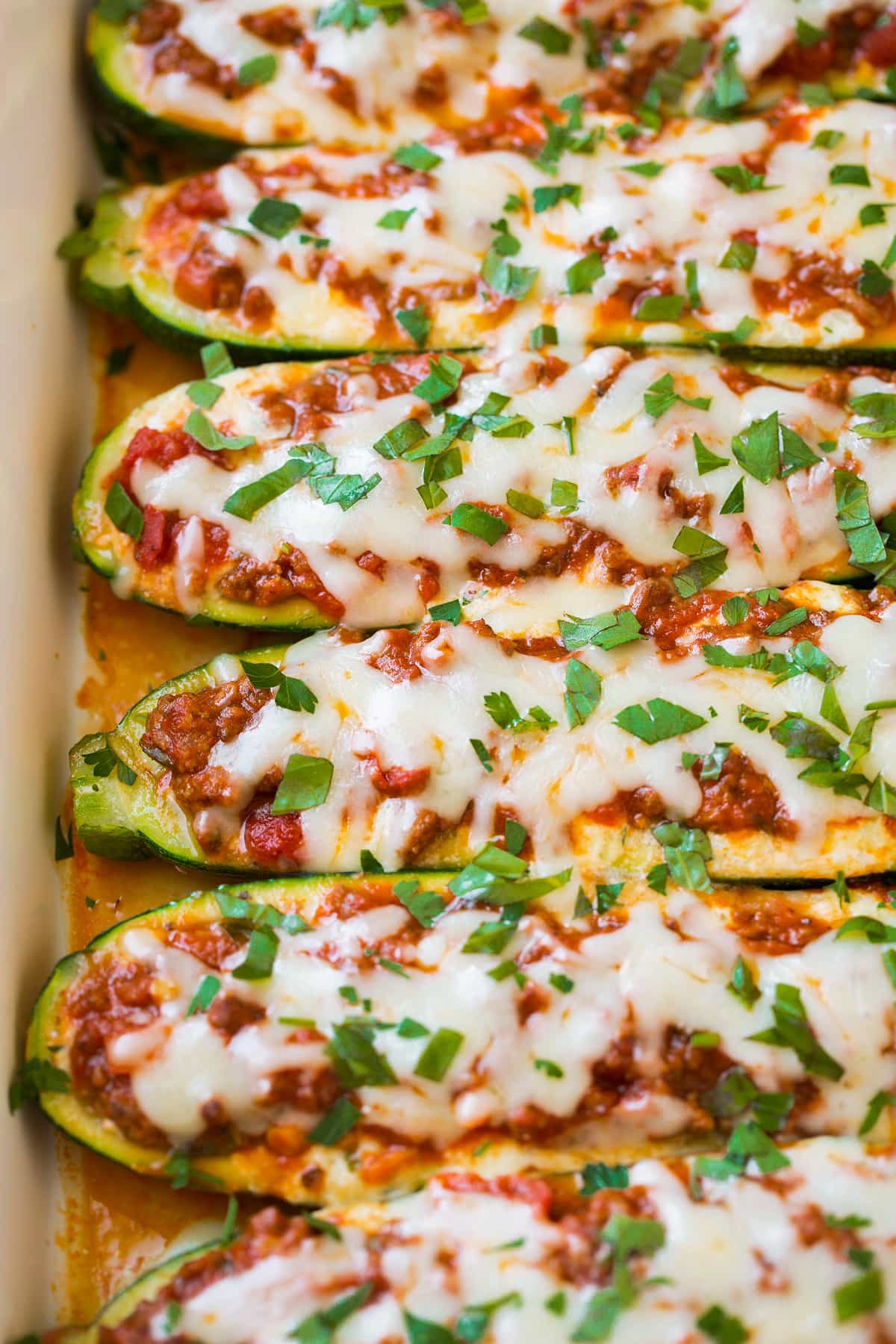 Lasagna Zucchini Boats Close up image of Lasagna Zucchini Boats in a row in baking dish.