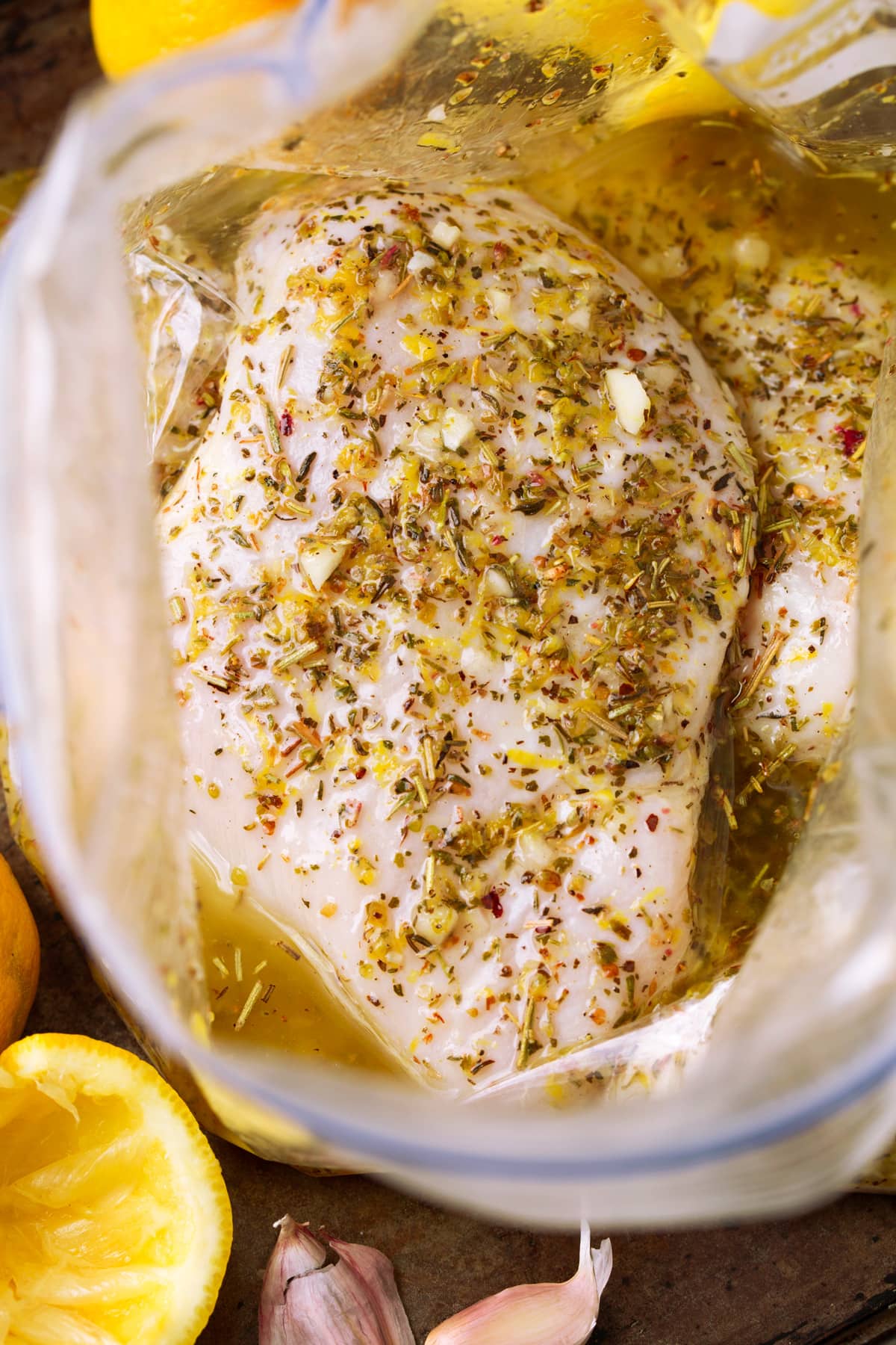 Greek lemon chicken soaking in marinade in a bag.