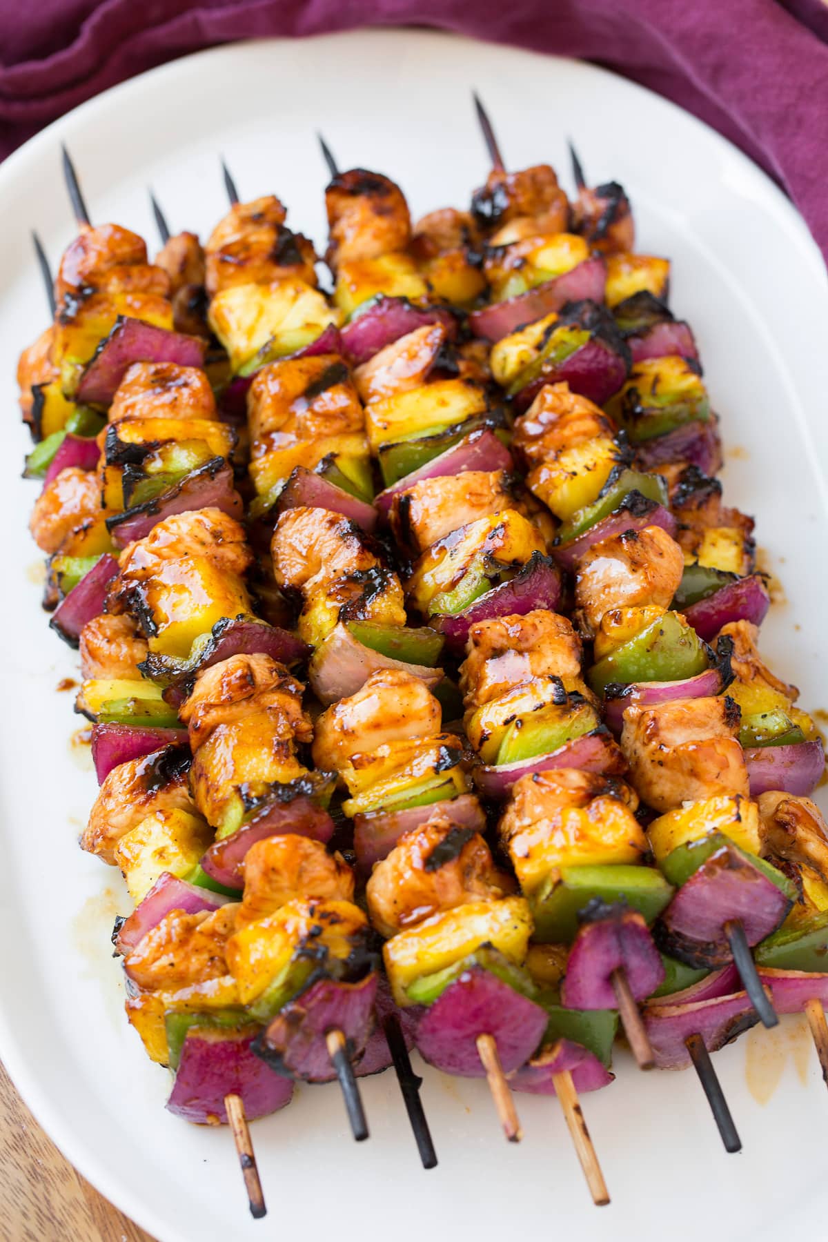 Hawaiian Chicken Kebabs Marinated hawaiian chicken skewers on a white serving plate.