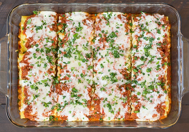 Lasagna Roll Ups. Not only look incredible but taste incredible. There's served in individual portions and are great for freezing too. | Lasagna Recipes | Easy Lasagna | #cookingclassy #lasagna #pasta #rollups Lasagna Roll Ups out of the oven with melted cheese and basil