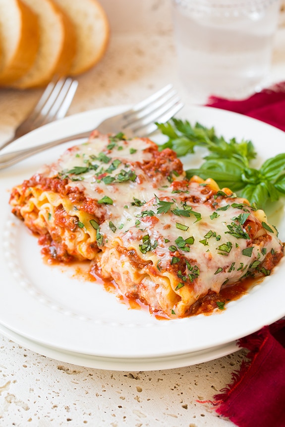 Lasagna Roll Ups. Not only look incredible but taste incredible. There's served in individual portions and are great for freezing too. | Lasagna Recipes | Easy Lasagna | #cookingclassy #lasagna #pasta #rollups Two Lasagna Roll Ups on a white plate with a fork