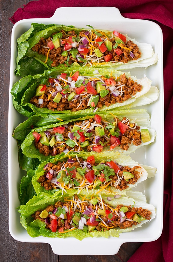 Make your weeknight tacos healthy with these Turkey Taco Lettuce Wraps! They're a breeze to throw together and are full of delicious flavors from ground turkey, delicious spices and all your favorite Mexican toppings. #cookingclassy #wraps #turkey Turkey Taco Lettuce Wraps in a white dish