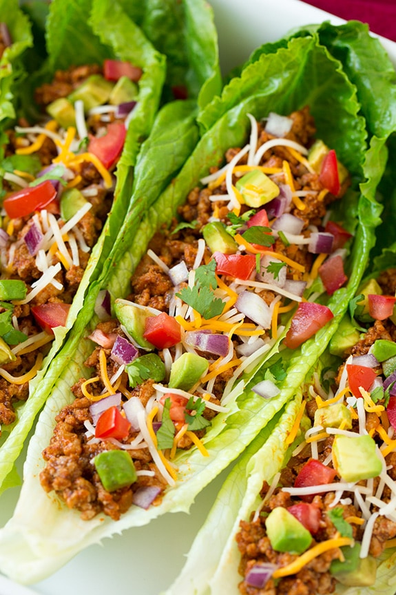 Make your weeknight tacos healthy with these Turkey Taco Lettuce Wraps! They're a breeze to throw together and are full of delicious flavors from ground turkey, delicious spices and all your favorite Mexican toppings. #cookingclassy #wraps #turkey Turkey Taco Lettuce Wraps topped with avocado, tomatoes and cheese