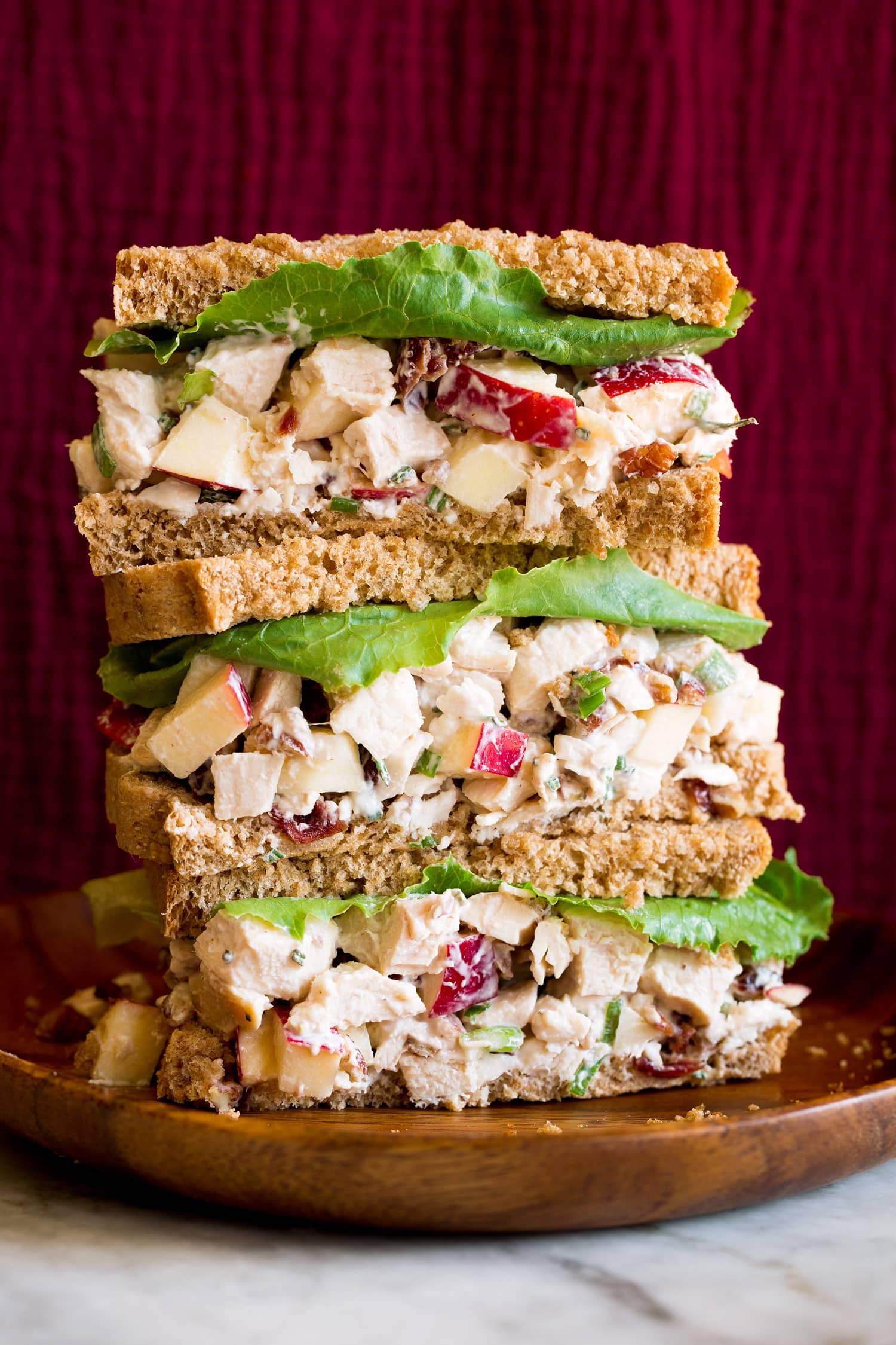 Apple Chicken Salad Chicken salad with apples shown in whole wheat bread slices as stacked sandwiches.