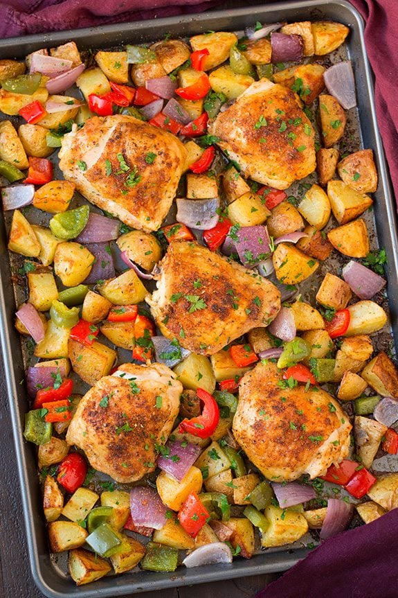 One Pan Cajun Chicken and Veggies Overhead image of baked cajun chicken thighs and veggies on a sheet pan.