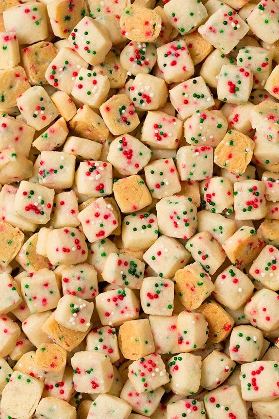 Funfetti Shortbread Bites. These fun little shortbread bites are perfect for the holidays. Made with Christmas sprinkles they make great gifts or snacks for parties. | Holiday Snacks | Holiday Desserts | #cookingclassy #funfetti #shortbread #Christmas A close up of Shortbread Bites with Christmas sprinkles