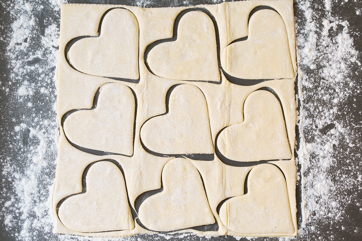 Cutting puff pastry into heart shapes.