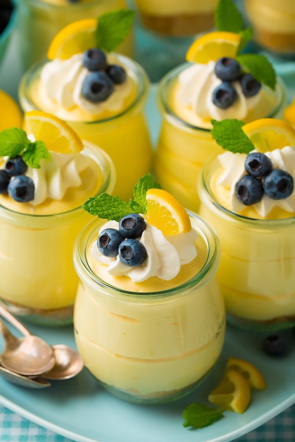 Soft, light and delicious this lemon mousse is the ultimate spring summer dessert. Made with a graham cracker base and a smooth, silky and luscious whipped cheesecake topping it's pretty hard to resist! #cookingclassy #lemon #cheesecake #mousse Lemon mousse in small glass jars