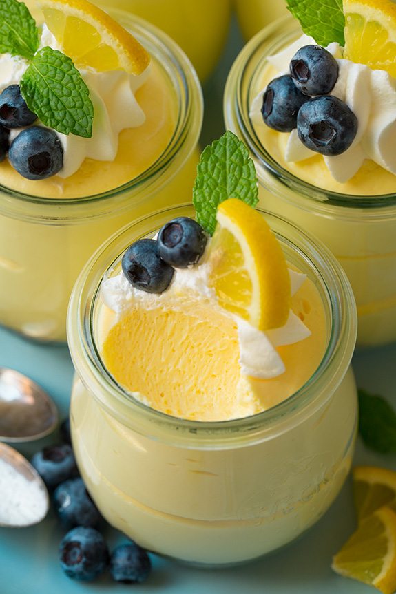 Soft, light and delicious this lemon mousse is the ultimate spring summer dessert. Made with a graham cracker base and a smooth, silky and luscious whipped cheesecake topping it's pretty hard to resist! #cookingclassy #lemon #cheesecake #mousse Close up of a Lemon Mousse with a spoonful missing