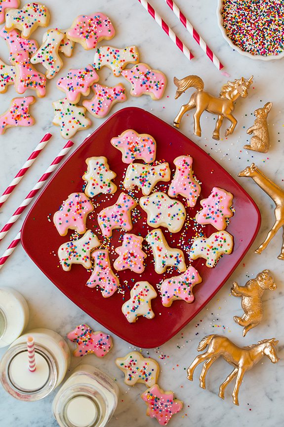 Homemade Circus Animal Cookies on red plate next to straws and glasses of milk