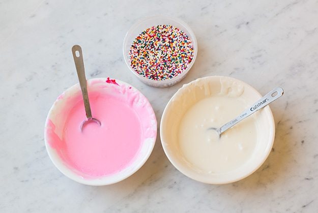 two bowls of vanilla icing with sprinkles