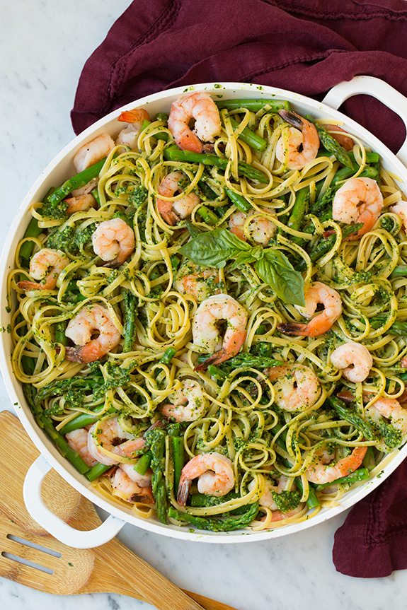 shrimp pesto pasta with asparagus in large white bowl