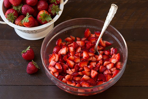 diced strawberries for strawberry shortcake trifles in glass bowl with spoon