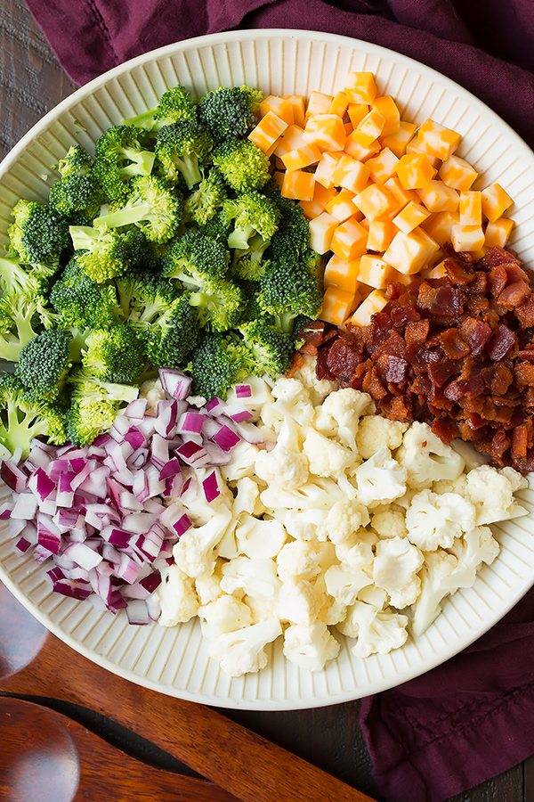Broccoli and Cauliflower Salad will quickly become a staple recipes! It's always a crowd favorite, who knew people could love broccoli so much? | Broccoli Salad | Salad Side Dish | Salad With Bacon | #cookingclassy #broccoli #salad #bacon #cheese Ingredients for a Broccoli and Cauliflower Salad in a white bowl
