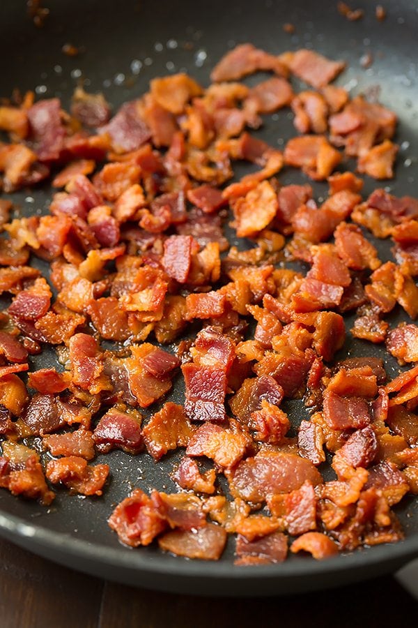 Broccoli and Cauliflower Salad will quickly become a staple recipes! It's always a crowd favorite, who knew people could love broccoli so much? | Broccoli Salad | Salad Side Dish | Salad With Bacon | #cookingclassy #broccoli #salad #bacon #cheese Bacon pieces frying in a pan for making a Broccoli and Cauliflower Salad