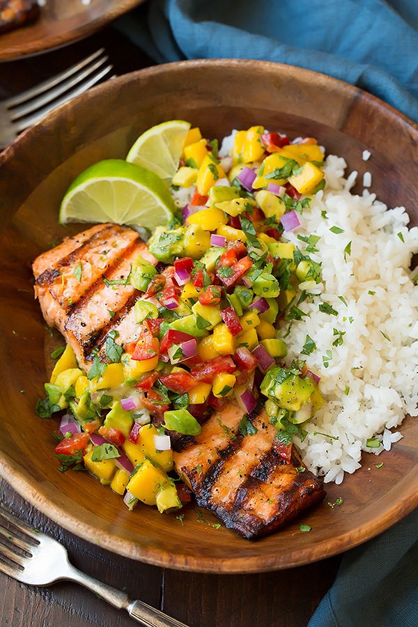 Grilled Lime Salmon in a wooden serving bowl topped with Mango Avocado Salsa and served with a side of Coconut Rice 
