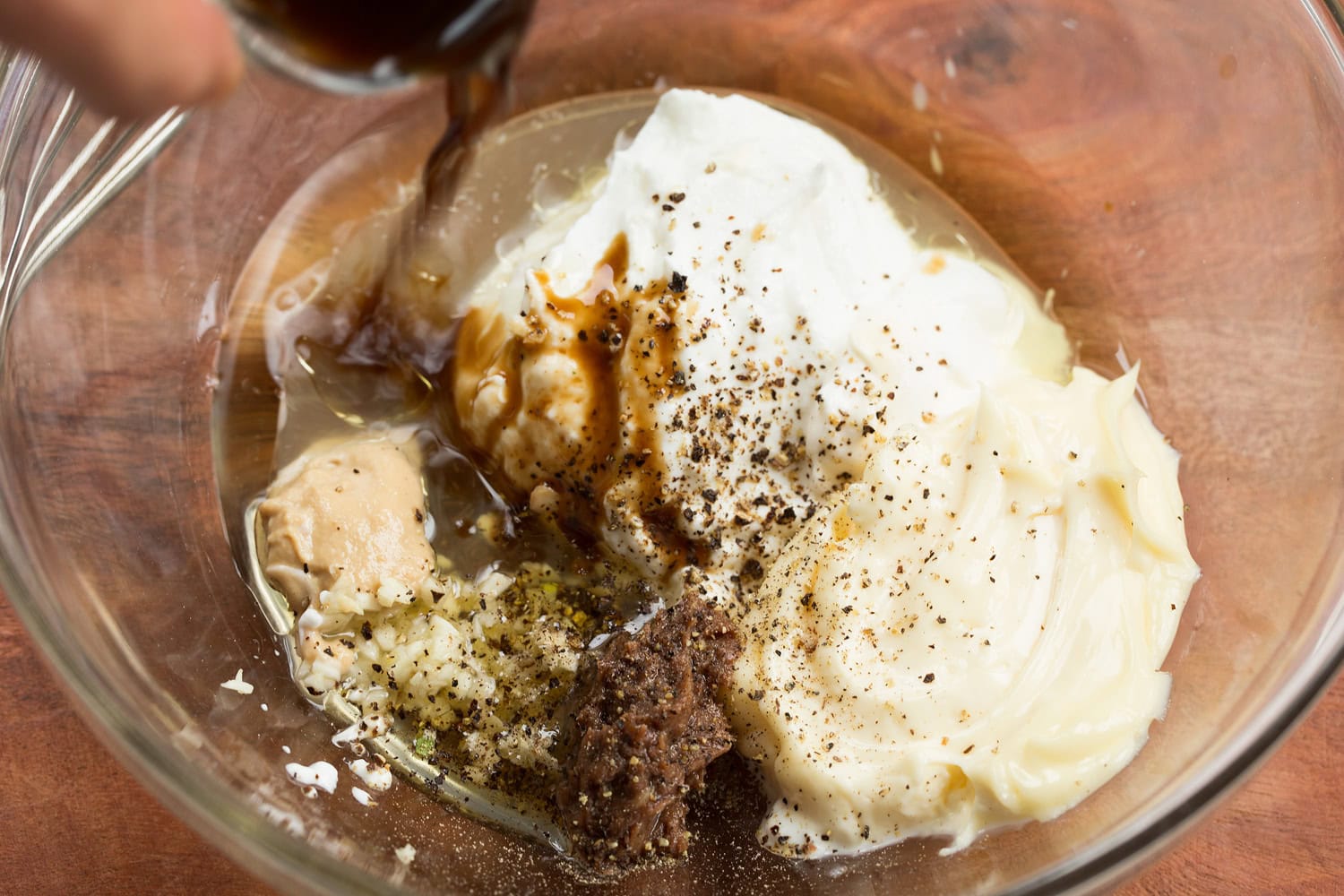 Chicken Caesar Wrap Caesar salad dressing ingredients in a glass mixing bowl shown before mixing.