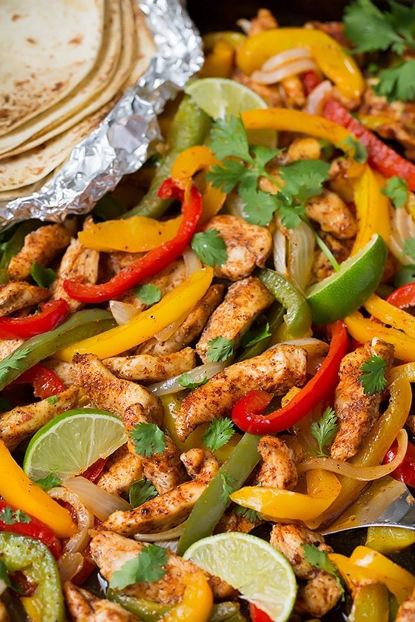 Chicken Fajitas Close up image of chicken fajita mixture on a dark sheet pan.