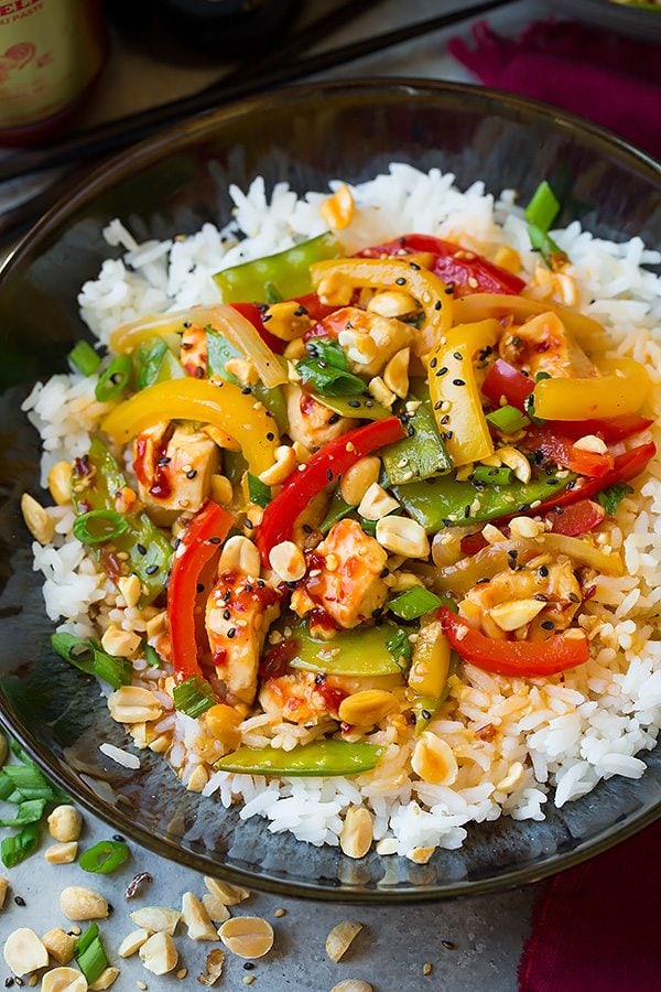 Szechuan Chicken Stir-Fry atop white rice in a dark bowl