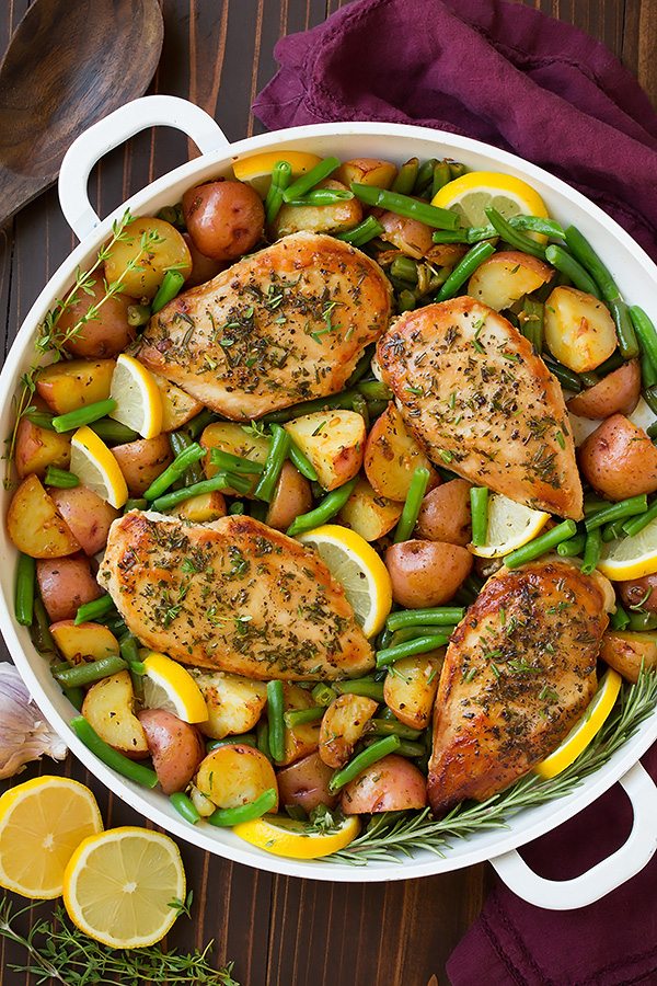 One Pan Garlic and Herb Chicken and Veggies Garlic and herb seasoned chicken breasts in a skillet with green beans, potatoes and lemons.