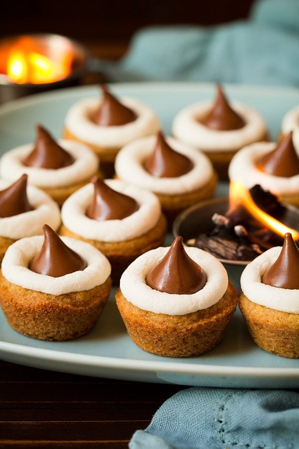 Mini S'mores Cookie Cups Mini S'mores Cookie Cups on a turquoise plate with a small fire in a cup in the center.