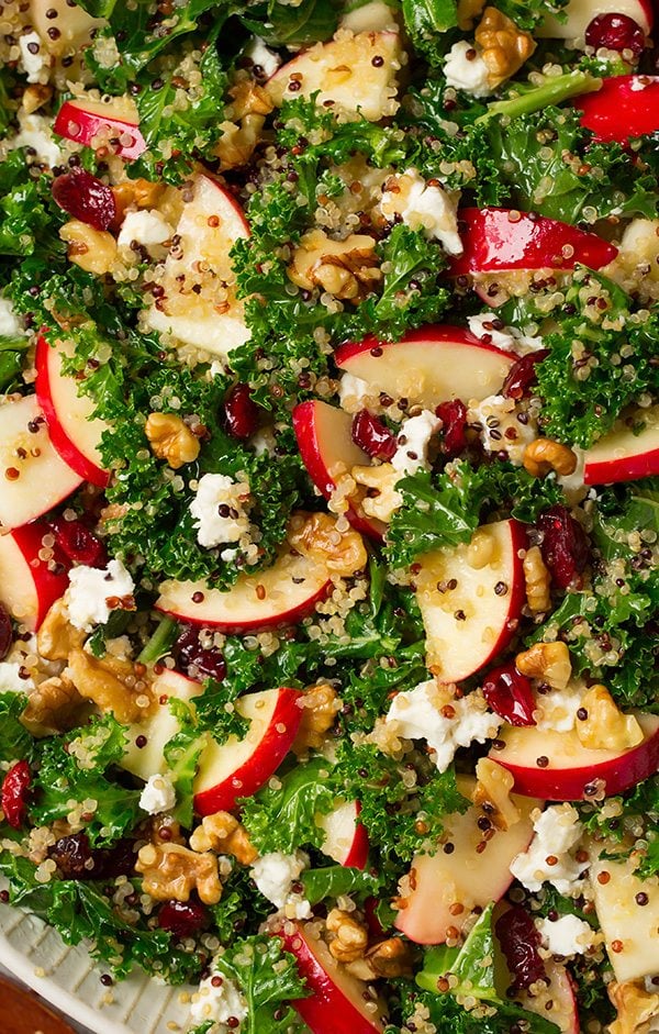 Autumn Apple Kale Quinoa Salad Close up image of kale salad with apples, quinoa, goat cheese and walnuts mixed in.