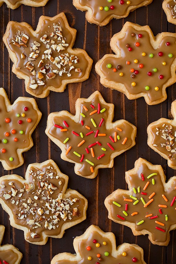 Glazed Maple Shortbread Cookies Leaf shape shortbread on a dark wooden surface.