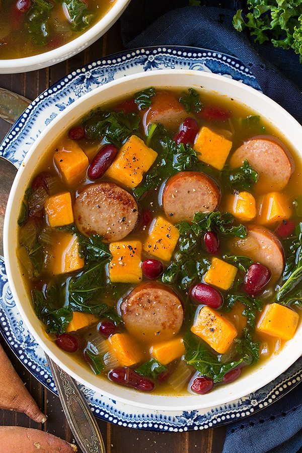 Turkey Sausage, Kale and Sweet Potato Soup Turkey Sausage, Kale and Sweet Potato Soup in a white serving bowl set over a vintage blue plate.