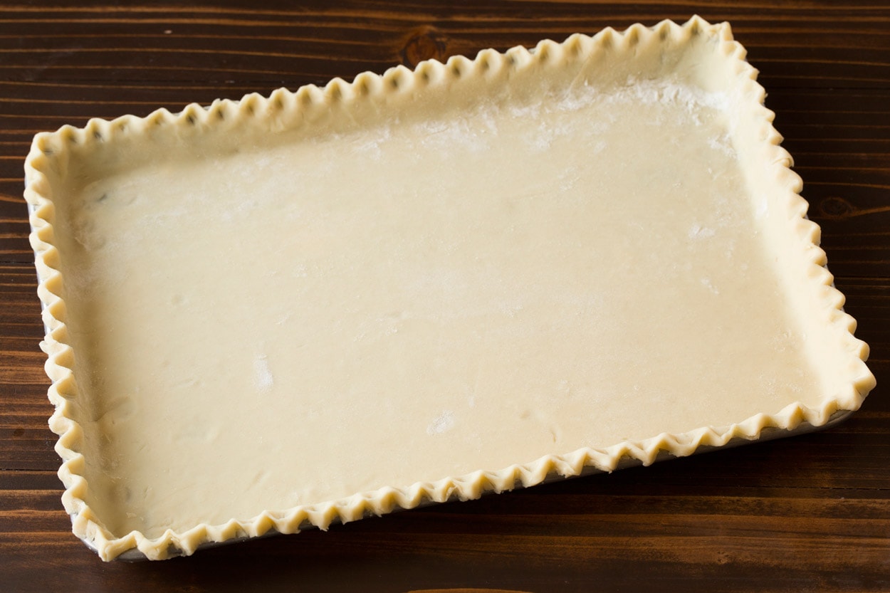 Apple Slab Pie Pie crust for apple slab pie on a rimmed baking sheet before adding filling.