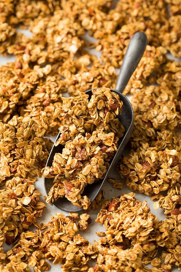 Honey Almond Granola Close up image of honey almond granola in a metal scoop.