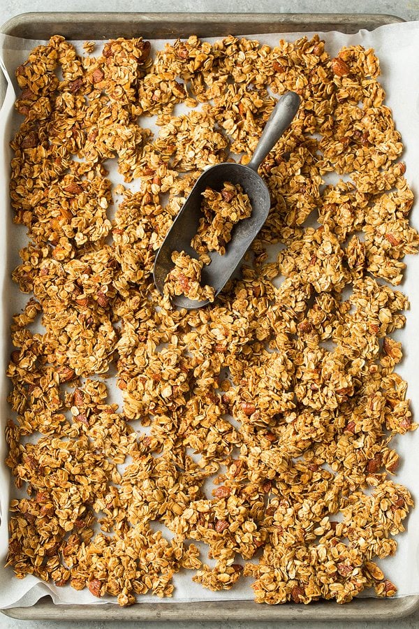 Granola Recipe Granola on a parchment paper lined baking sheet after cooking.